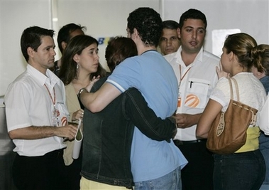 Relatives of passengers of a missing Gol jet, wait for information at the Antonio Jobim International Airport in Rio de Janeiro, Brazil, on Friday, Sept. 29, 2006. A Gol airlines jet with a 150 people aboard was missing Friday over the Brazilian Amazon after a midair collision with a smaller executive jet, Brazilian aviation authorities said. Wladimir Caze, spokesman for the Brazilian aviation authority, said Gol flight 1907 left the jungle city of Manaus and disappeared after a collision. It had been scheduled to land in Brasilia before heading to Rio de Janeiro's Antonio Jobim International Airport. (AP Photo/Silvia Izquierdo) 