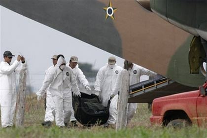 Recovery workers carry human remains from last week's plane crash in the Brazilian Amazon to a military airplane at the base of operation of the Brazilian Air Force, at the Jarina Farm, in the northeast area of the Brazilian state of Mato Grosso, Wednesday, Oct. 4, 2006. Prosecutors could charge two American pilots of an executive jet with manslaughter for a high-altitude collision with a Boeing 737 that apparently led to 155 deaths, federal police said Wednesday. (AP Photo