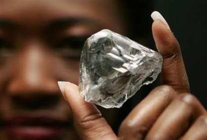 A model displays a rare 603 carat white diamond sold for $12.36 million during a news conference in Antwerp, October 9, 2006. The diamond, the 'Lesotho Promise', will be cut up and sold for an expected $20 million. (Francois Lenoir/Reuters