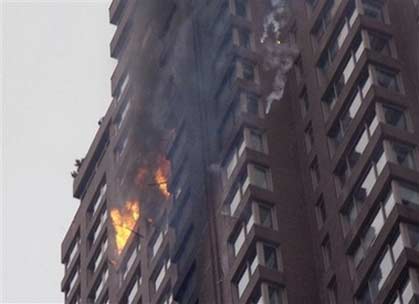Debris falls from an apartment building on New York's Upper East Side after a small plane with New York Yankees pitcher Cory Lidle aboard crashed into it Wednesday, Oct. 11, 2006. (AP 