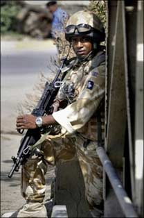 A British soldier moves into position during a patrol in the southern Iraqi city of Basra, October 18. Most Britons want a swift withdrawal of their nation's troops from Iraq, according to two new polls, despite Prime Minister Tony Blair's vows to see the mission through.(