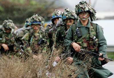 Soldiers march during a military exercise in Pochon, about 46 km (29 miles) northeast of Seoul, October 23, 2006. U.N. Secretary General-designate Ban Ki-moon will visit China on Friday for talks on ending North Korea's nuclear weapons programme and accelerating moves by U.N. members to sanction Pyongyang for conducting a nuclear test. 