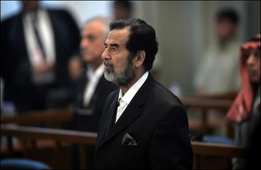 Ousted Iraqi leader Saddam Hussein stands as a witness (not seen) is sworn in for testimony during his trial held in Baghdada??s heavily fortified Green Zone on October 19. Saddam's defence team has drafted a letter to US President George W. Bush warning of dire consequences if an Iraqi court issues a verdict against the ousted Iraqi president for crimes against humanity.(AFP