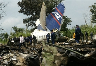 People walk at the site of an airplane crash site in Abuja, Nigeria, Monday, Oct. 30, 2006. The pilot of a Nigerian airliner that crashed a day earlier did not heed air traffic controllers' advice to wait for stormy weather to clear before taking off, the minister of aviation said Monday. The pilot was among 96 people killed in the crash; nine people survived. (AP