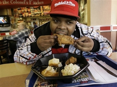 Edward Patterson, a Kentucky Fried Chicken employee, chows down on some of the company's trans fat-free product in New York, Monday, Oct. 30, 2006. KFC said Monday it is phasing out trans fats in cooking its Original Recipe and Extra Crispy fried chicken, Potato Wedges and other menu items, but hasn't found a good alternative yet for it's biscuits. (AP