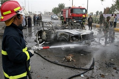 Iraqi fireman hose a car bomb wreck in Baghdad, Tuesday Oct. 31 2006. Three people were killed and five were hurt in the blast. (AP 