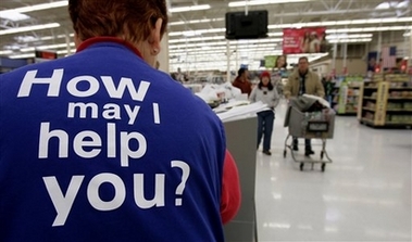 Customers at a Wal-Mart store head to the checkout lines past a worker with the company's motto on the back of her vest Nov. 13, 2005 in a Salt Lake City file photo. Wal-Mart Stores Inc. has tightened its attendance policy for its store workers, including reducing the number of permitted unexcused absences, and taking a more punitive approach to those who show up 10 minutes late for work or leave early to take care of a sick child. The policy is likely to draw a firestorm from labor advocates and critics of how the world's largest retailer treats its workers. (AP 
