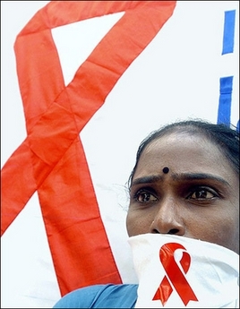 A woman stands before a banner featuring a large red ribbon, the internationally-known symbol of AIDS prevention. India is making perilous mistakes in its fight against AIDS by assuming the human immunodeficiency virus (HIV) is being spread overwhelmingly by sex and especially by prostitutes, a study warns.(AFP