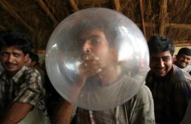 A truck driver blows up a condom during an AIDS awareness campaign event called a 'condom party,' organized by a non-government organisation (NGO) in Guragon, in the northern Indian state of Haryana June 9, 2006. Indian authorities want to stop the daytime airing of a television advertisement promoting flavoured condoms saying it is obscene and in bad taste, a newspaper reported Friday.
