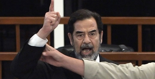 Former Iraqi President Saddam Hussein yells in court as he receives his verdict, as a bailiff attempts to silence him, during his trial held under tight security in Baghdad's heavily fortified Green Zone November 5, 2006. A visibly shaken Saddam Hussein was found guilty of crimes against humanity and sentenced to hang on Sunday at a lightning session of the U.S.-backed court trying him in Baghdad. 