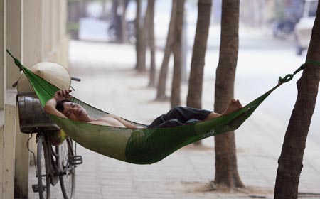 A man rests along a sidewalk in Hanoi November 12, 2006. Vietnam is the host of this year's Asia-Pacific Economic Cooperation (APEC) meeting scheduled from November 12 till 20.