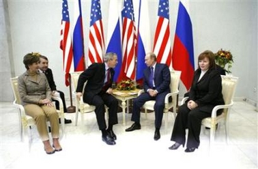 President Bush meets with Russian President Vladimir Putin upon Bush's arrival in Moscow, November 15, 2006. At left is Laura Bush and at right is Lyudmila Putina.