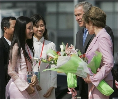 US President George W. Bush and First Lady Laura Bush chat with Vietnamese girls after they were presented with bouquets upon arrival at Noi Bai International Airport in Hanoi.(AFP