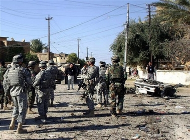.S. troops inspect the site following an explosion in Kirkuk, northern Iraq, Friday, Dec. 1, 2006. A suicide bomber targeting an American convoy killed two civilians and wounded three, police said. (AP Photo