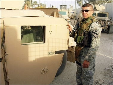 Iraqi translator for US forces Omar Satar Hussein opens the door of an armored US Humvee, west of the restive city of Baquba, northeast of Baghdad, 02 December 2006.