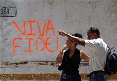 People stand next to grafitti reading 'Viva Fidel' on a street in Havana in this file photo. Castro has spoken by telephone to a meeting of Cuban officials, the ruling Communist Party newspaper Granma said on Saturday in the first official word on the 80-year-old leader in 11 days. (Claudia Daut/Reuters