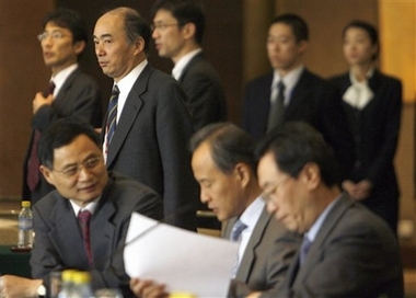Top Japanese envoy Kenichiro Sasae, standing in second row, arrives for the resumption of Six-Party Talks as China's Deputy Foreign Mminister Wu Dawei , seated at right, gathers his notes ahead of round-table discussions at the Diaoyutai State Guesthouse in Beijing Monday, Dec. 18, 2006. International talks on North Korea's nuclear program convened Monday for the first time in 13 months following a boycott by the communist nation during which it tested an atomic device for the first time. (AP