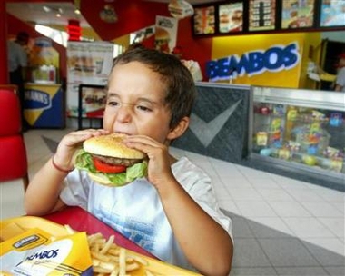 A boy bites into a hamburger in a 2004 file photo. A hotel in Indonesia is dishing out a hamburger that costs more than twice the monthly minimum wage in some parts of the country. (Pilar Olivares/Reuters