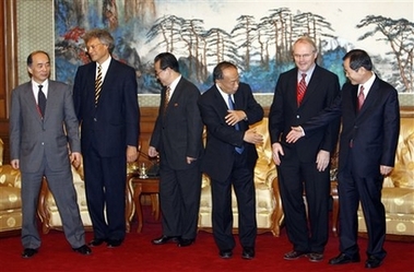 Chinese Foreign Minister Li Zhaoxing, third from right, initiates a joining of hands after a group photo of top envoys to six-party talks on North Korea's nuclear weapons Wednesday, Dec. 20, 2006, at the Diaoyutai State Guesthouse in Beijing. From left are, Japan's Kenichiro Sasae, Russia's Sergey Razov, North Korea's Kim Kye Gwan, Li, the United States' Christopher Hill and South Korea's Chung Yung-woo. (AP 