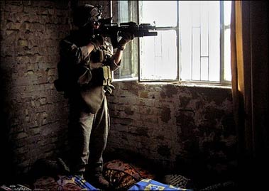 A US Marine monitors a street as his squad searches an abandoned house after being targeted by small arms fire in the restive city of Ramadi in November 2006. 