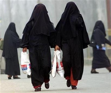 Burqa clad women walk at a busy market place in Srinagar, January 21, 2003. Women wearing the burqa and other face-concealing veils could be banned from jewelry stores in a west Indian city after a spate of thefts involving burqa-clad customers, jewelers said on Thursday. [Reuters]