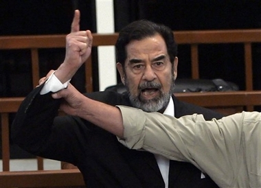 Former Iraqi President Saddam Hussein yells at the court as a bailiff attempts to silence him as the verdict is delivered during his trial held under tight security in Baghdad's heavily fortified Green Zone, Sunday Nov. 5, 2006. Iraq's High Tribunal on Sunday found Saddam Hussein guilty of crimes against humanity and sentence him to die by hanging. (AP