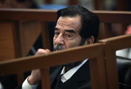 Saddam Hussein pauses as he listens to a witness testimony during his trial in Baghdad's heavily fortified Green Zone October 9, 2006.
