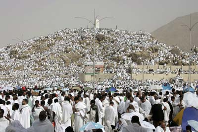 Muslim pilgrims performing the haj climb the Jebel al-Rahma (Mount Mercy) at the plain of Arafat, near Mecca, December 29, 2006. More than 2 million elated Muslim pilgrims crowded onto holy Mount Arafat near Mecca on Friday, praying for Muslims around the world and hoping for a safe haj. 