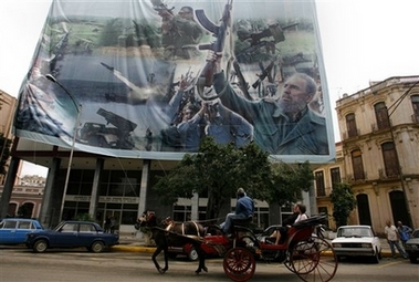 Tourists in a carriage ride past a billboard with an image of Cuba's President Fidel Castro in Havana, Wednesday, Dec.27, 2006. A Spanish surgeon who has just examined Castro said on Tuesday he is making good recovery from intestinal surgery and does not have cancer.(AP
