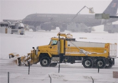 A snowplow clears a pathway from the terminal to the taxiway at Denver International Airport, Friday, Dec. 29, 2006, in Denver. The second major snow storm in a week pounded Colorado on Friday, burying the foothills under another 2 feet of snow, shutting down highways and forcing the cancellation of hundreds of flights at the Denver airport. (AP