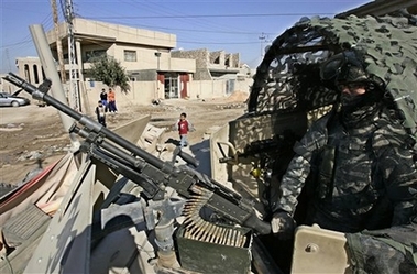 A U.S. Army soldier from the 2nd Battalion, 17th Field Artillery Regiment scans a street from the top of a Humvee in Baghdad, Iraq, on Monday, Jan. 1, 2007 (AP