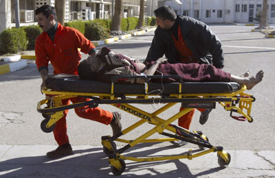 A bombing victim is rushed to Yarmouk hospital in Baghdad January 4, 2007. Two bombs exploded at a petrol station in Baghdad's western Mansour district on Thursday, killing 13 people and wounding 22, police and an interior ministry source said.