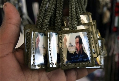 A Palestinian vendor displays necklaces showing former Iraqi President Saddam Hussein in his shop in the West Bank town of Jenin, Thursday, Jan. 11, 2007. (AP