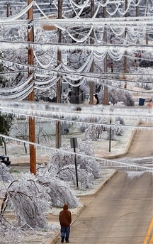 A pedestrian walks underneath ice-covered power lines near downtown McAlester, Okla., Tuesday, Jan. 16, 2007. 