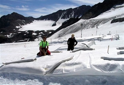 Marc Olefs and Andrea Fischer, from left, researchers from Innsbruck University, check a field covered with white polyethylene against the backdrop of jagged peaks, at Eisgrat (Ice Spine) skiing station on Stubai glacier near the village of Neustift-im-Stubaital, in this July 4, 2005 file photo. Most glaciers will disappear from the Alps by 2050, scientists told a conference on climate change Monday, Jan. 22, 2007, basing their bleak outlook on evidence of slow but steady melting of the region's continental ice sheets. (AP Photo