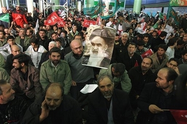 An Iranian man holds a picture of the late revolutionary foundar Ayatollah Khomeini at his mausoleum, just outside Tehran, Iran, Thursday, Feb. 1, 2007, in a ceremony commemorating the 28th anniversary of his return from exile. On Feb. 1, 1979, after 14 years in exile, Ayatollah Ruhollah Khomeini returned from Paris and became the de facto leader of Iran. [AP]