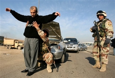 Iraqi army soldiers search a driver at a vehicle checkpoint in Baghdad, Iraq, Thursday, Feb. 15, 2007.