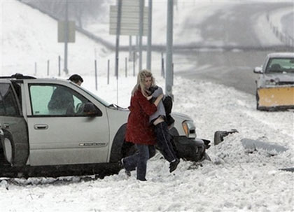 Motorists whose car ended up in the ditch on Interstate 80 west of Omaha, Neb., evacuate their car , Sunday, Feb. 25, 2007. A blizzard in western Nebraska Saturday threatened roads and power, as cars slid off roads and whiteout conditions prompted officials to temporarily close more than 270 miles of westbound I-80, across more than half the state.(AP Photo