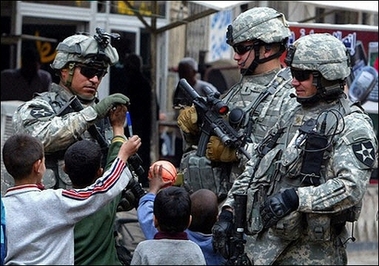 US soldiers play with Iraqi children during a patrol in Baghdad. US Democrats unveiled a double-pronged attack on President George W. Bush over Iraq Thursday, demanding the withdrawal of all US combat troops from the unpopular war as early as March 2008. [AFP]