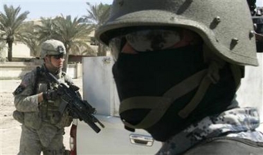 A U.S. soldier (L) from Delta company 2/325, 82nd Airborne and an Iraqi national police officer conduct a joint patrol in Baghdad's Sadr City March 11, 2007. 1
