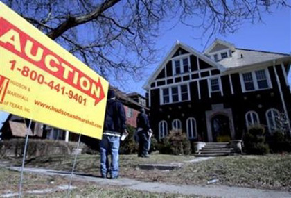 An auction lawn sign points to a foreclosed property to be auctioned off by Dallas-based Hudson and Marshall along with several hundred other foreclosed homes in Detroit, Michigan March 18, 2007. Job losses in the U.S. industrial heartland have left states like Michigan and Ohio more vulnerable to mortgage defaults, as home finance costs rise amid often moribund real-estate markets. (Rebecca Cook/Reuters