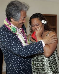 Japanese billionaire Genshiro Kawamoto, left, hugs Dorie-Ann Kahale after handing over keys to a multimillion-dollar home in the exclusive Kahala neighborhood for her and her family to live in rent-free, Thursday, March 22, 2007, in Honolulu. Kawamoto selected eight Native Hawaiian families that will each rent one of his multimillion-dollar homes in the oceanside neighborhood. (AP Photo