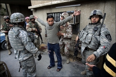 An Iraqi man holds his arms up as US soldiers search him for weapons in the predominantly Sunni al-Dora neighborhood of southern Baghdad.