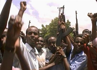Somali insurgents raise their AK-47 rifles in celebration as they roam through Shirkole neighbourhood in Mogadishu March 29, 2007.