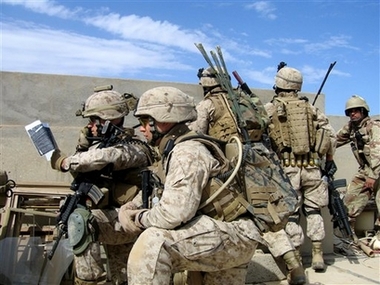 Marine Maj. Jim Lively, left, studies a map and radios fellow American units during a gunfight on Tuesday, March 27, 2007, in Ramadi, Iraq, 115 kilometers (70 miles) west of Baghdad.