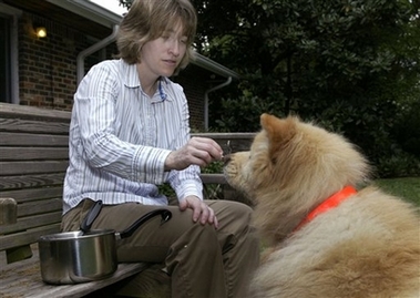 Amy Parish offers food to her dog in her backyard in Tucker, Ga., Tuesday, April 3, 2007.