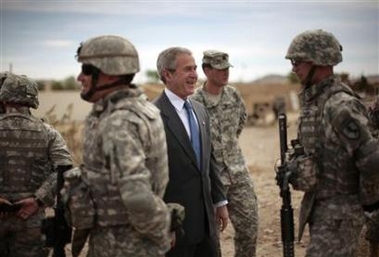 U.S. President George W. Bush laughs among soldiers during his visit to the National Training Center at Fort Irwin in the Californian desert, April 4, 2007.