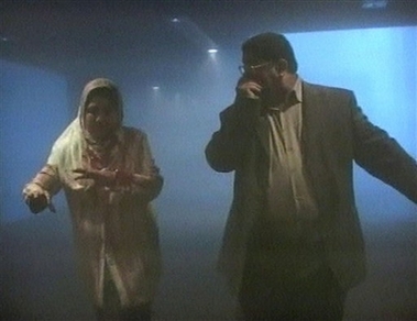 Image from television via AP Television News shows a man and a woman leaving the area through thick dust following an explosion in the Iraqi parliament cafeteria within the Green Zone in Baghdad, Iraq. Thursday April 12, 2007. 