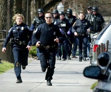 Blacksburg police officers run from Norris Hall on the Virginia Tech campus in Blacksburg, Va., Monday, April 16, 2007.