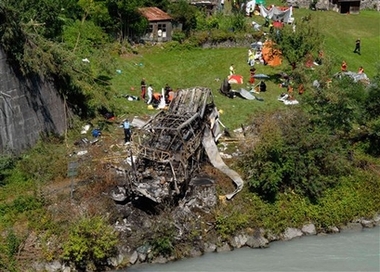 View of the wreckage of a bus that was transporting Polish pilgrims from a holy site in the French Alps, after it plunged off a steep mountain road, crashed into a river bank and burst into flames, Sunday, July 22, 2007 by the Romanche river in Vizille, south of Grenoble, killing 26 people, authorities said.